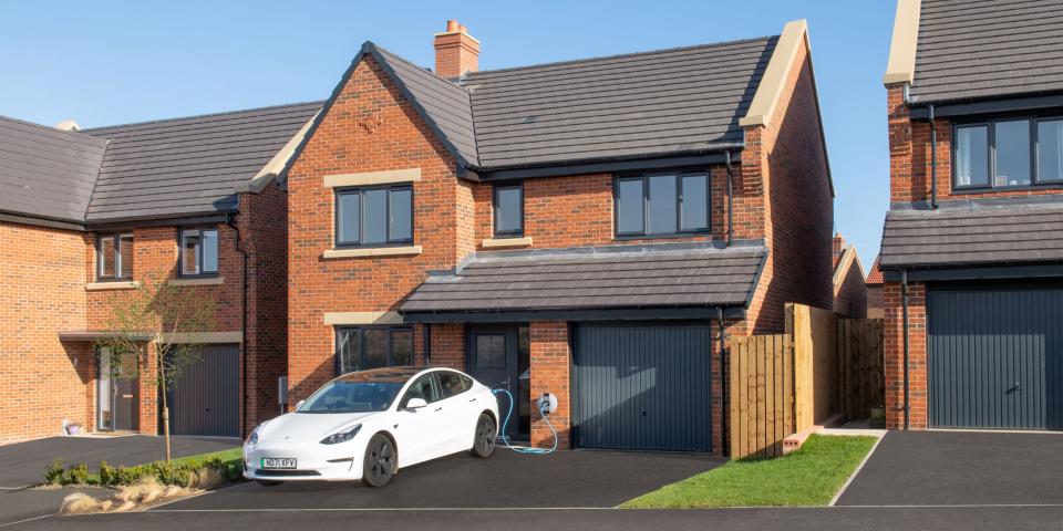 Electric vehicle being electrically charged in a driveway