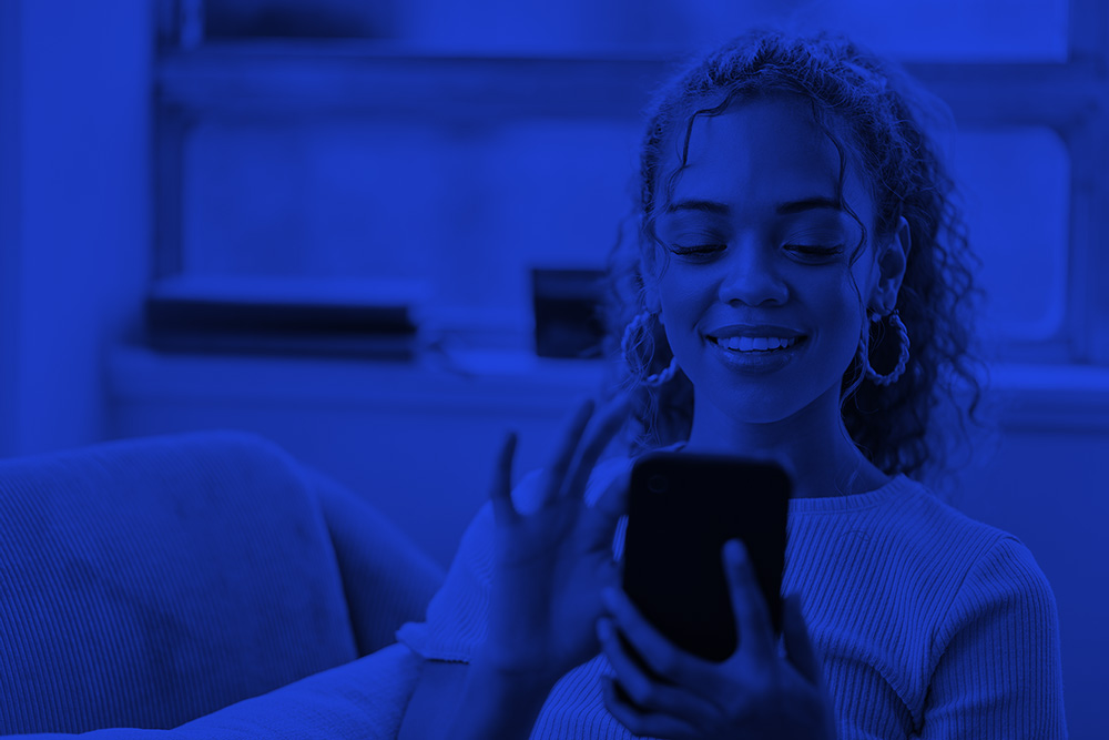 woman reading newsletter on a phone