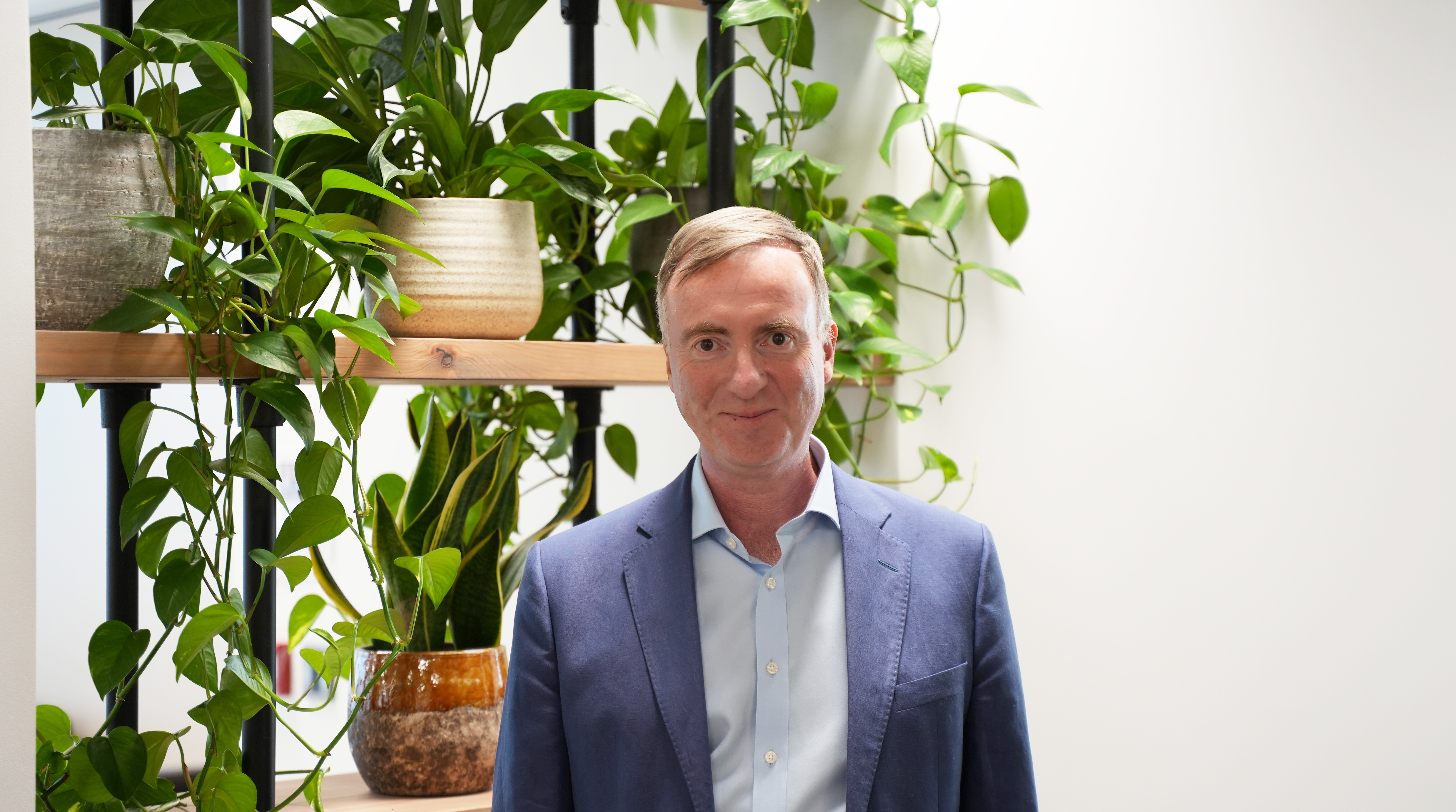 Michael Rea in front of plants in the office