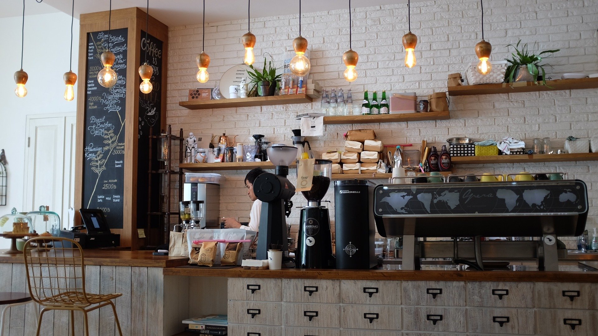 coffee shop counter featuring plants and hanging lights