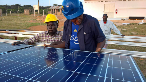 Africa man inspecting a solar panel
