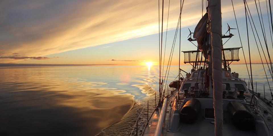 image of a ship sailing at sunset