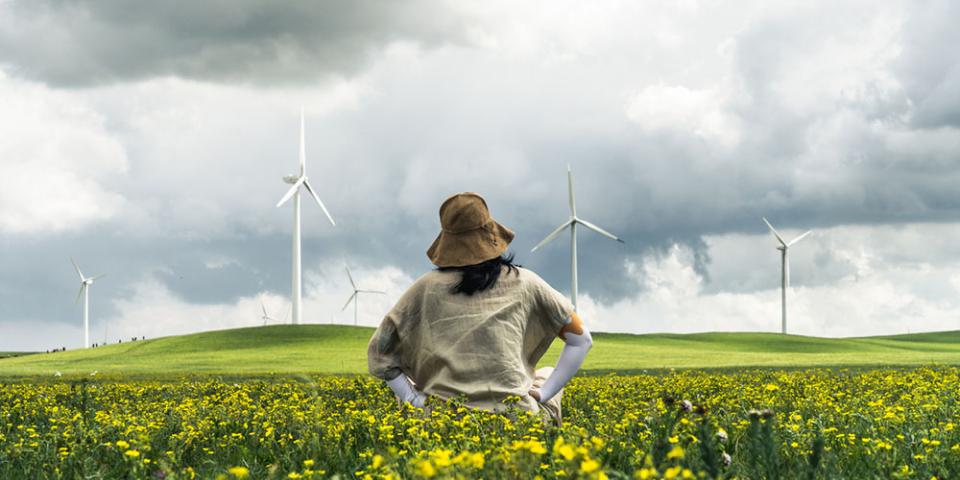 Person in field with wind turbine