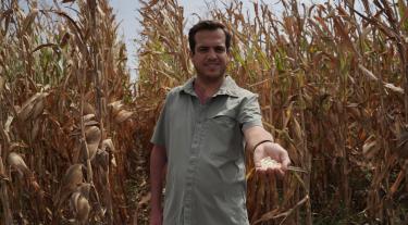 Person in a field with hand outstretched