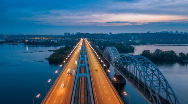 image of a road by a bridge at dusk