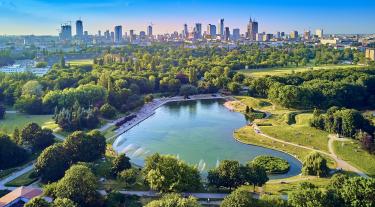 City skyline with lake and greenery in the foreground