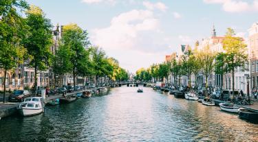 Amsterdam view of houses lining a canal with boats
