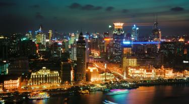 view of buildings across a river in China at night