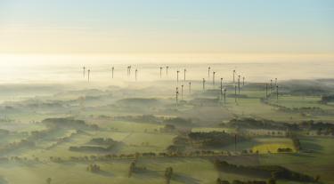 Landscape at sunrise and fog with wind turbines