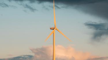 windmill in the sun against a blue sky with clouds